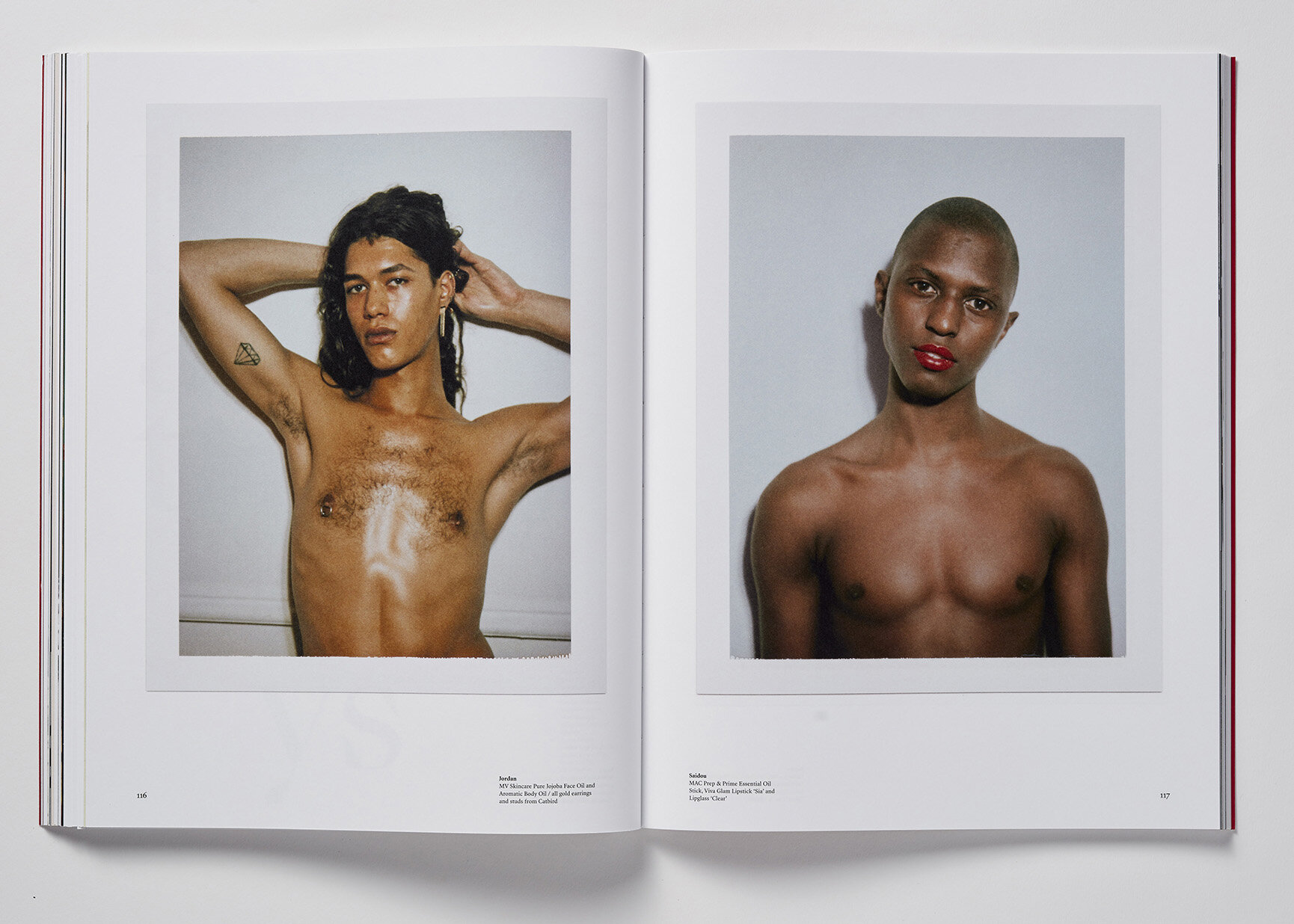 Two portraits of shirtless people with different skin tones are showcased side-by-side in an open book against a white background.