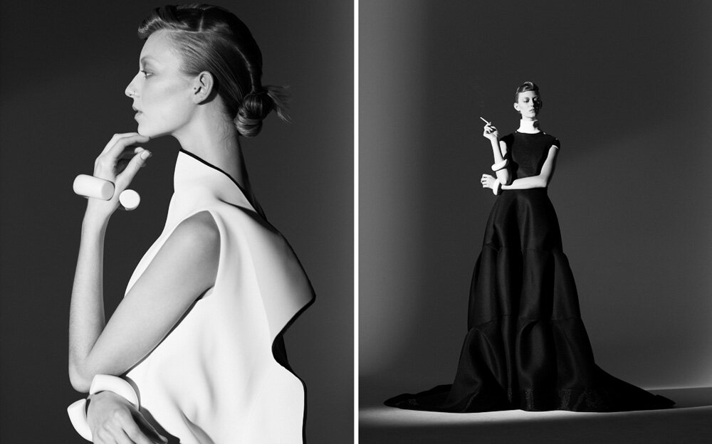 Elegant black and white fashion shot featuring a woman in a white dress (left) and a woman in a black gown (right), studio setting.