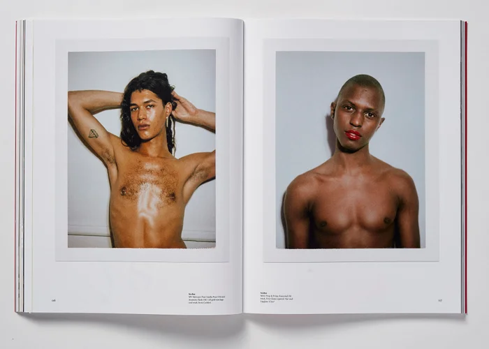 Open magazine spread showing two polaroid portraits of shirtless men with tattoos and red lipstick against plain walls