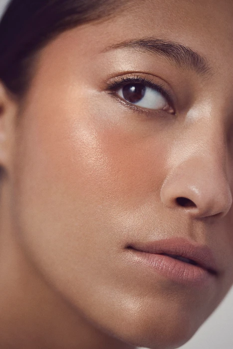 Extreme close up portrait of a woman showing glowing skin, natural makeup and subtle blush photographed by Paul Westlake.