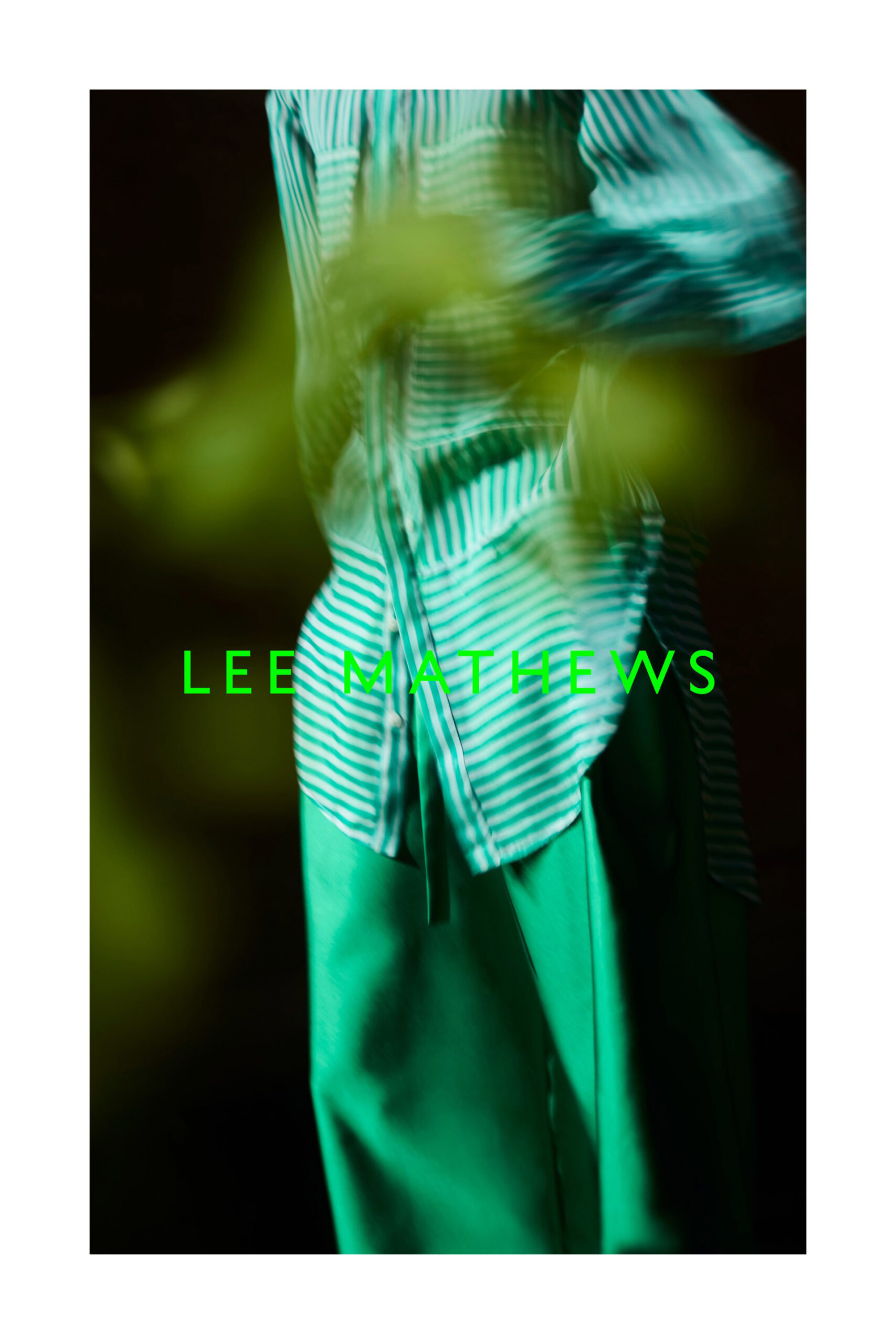 Model wearing a green striped shirt and loose green trousers with bright green LEE MATHEWS typography overlay.