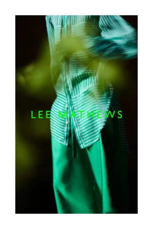 Model wearing a green striped shirt and loose green trousers with bright green LEE MATHEWS typography overlay.