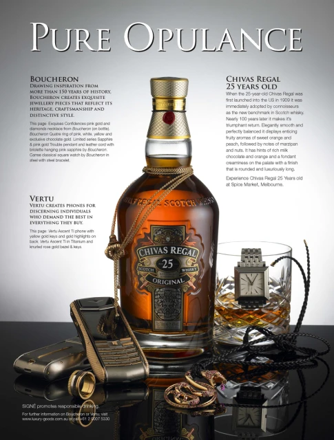 Still life shot showcasing a bottle of Chivas Regal whisky, rings, watches, necklaces, and Vertu phones on a black reflective surface.