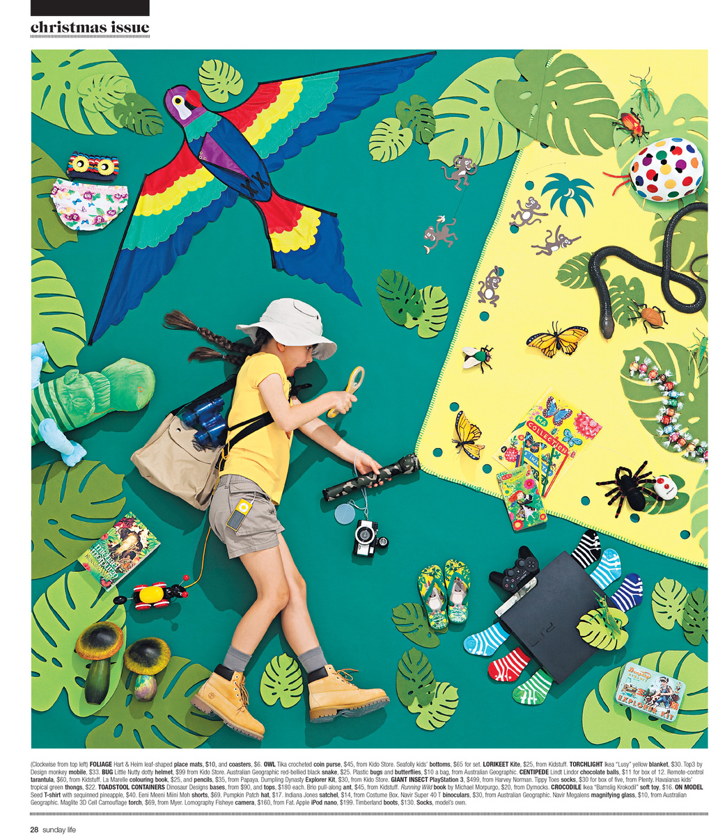 Child explores a vibrant jungle scene with a colorful parrot kite, surrounded by paper leaves, toys, and jungle-themed objects against green and yellow.