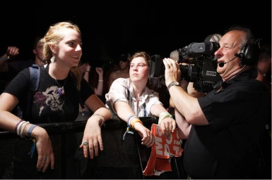 Cameraman filming crowd at concert with a professional broadcast camera