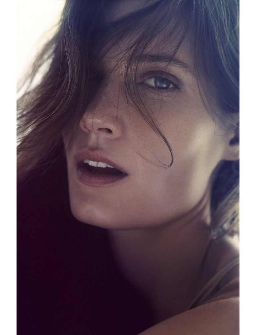 Close up portrait of a woman with loose hair falling across her face photographed by Will Davidson