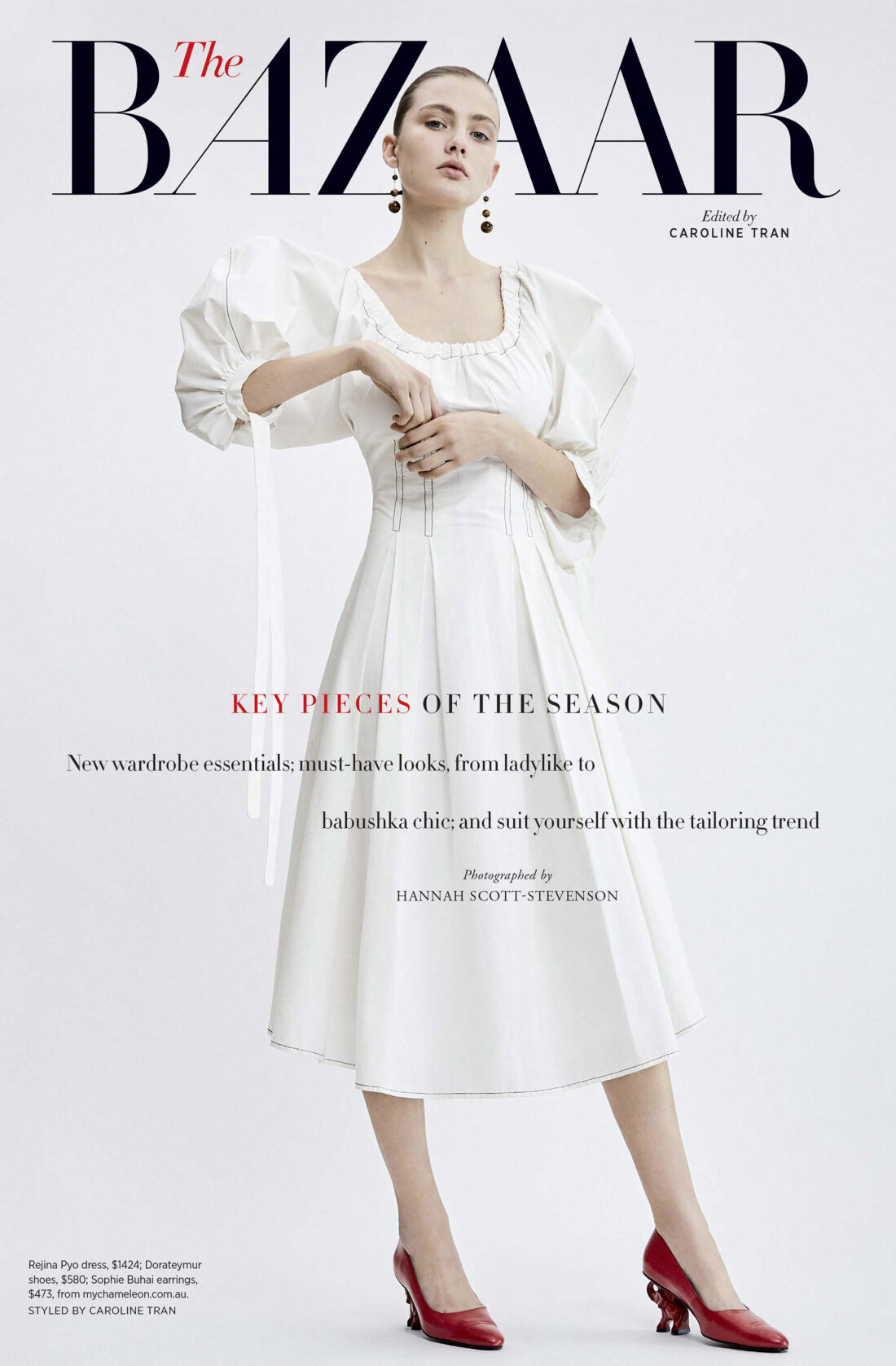 Fashion editorial shot of a fair-skinned adult female model wearing a white dress and red shoes, posing on a neutral background.