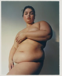A woman posing in low-angle portrait framing against a neutral gradient background, captured by Hannah Scott-Stevenson.