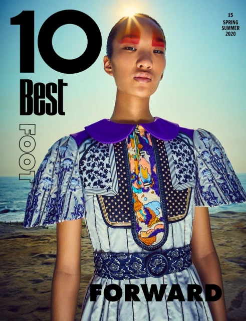 Magazine cover featuring an Asian model in a patterned dress against a sky and ocean backdrop, highlighting fashion and beauty trends.