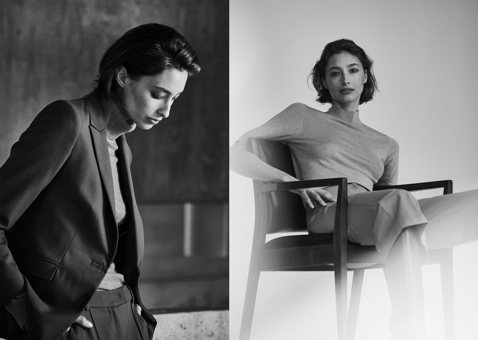 Black and white fashion portrait of two women in tailored suits, one seated, with modern clothing, against a neutral background.