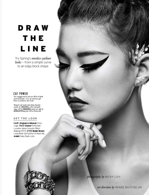 Black and white beauty shot of Asian woman with extreme winged eyeliner and jeweled hair accessories, close-up shot with soft lighting.