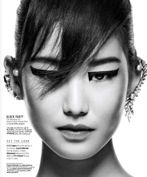 Close-up monochrome portrait of a model with dramatic graphic eyeliner and intricate ear cuffs, featuring hair styling by Emma Haddock.