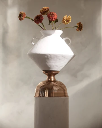 Still life photograph of flowers in a white vase on a pedestal, featuring a soft color palette and elegant composition. 