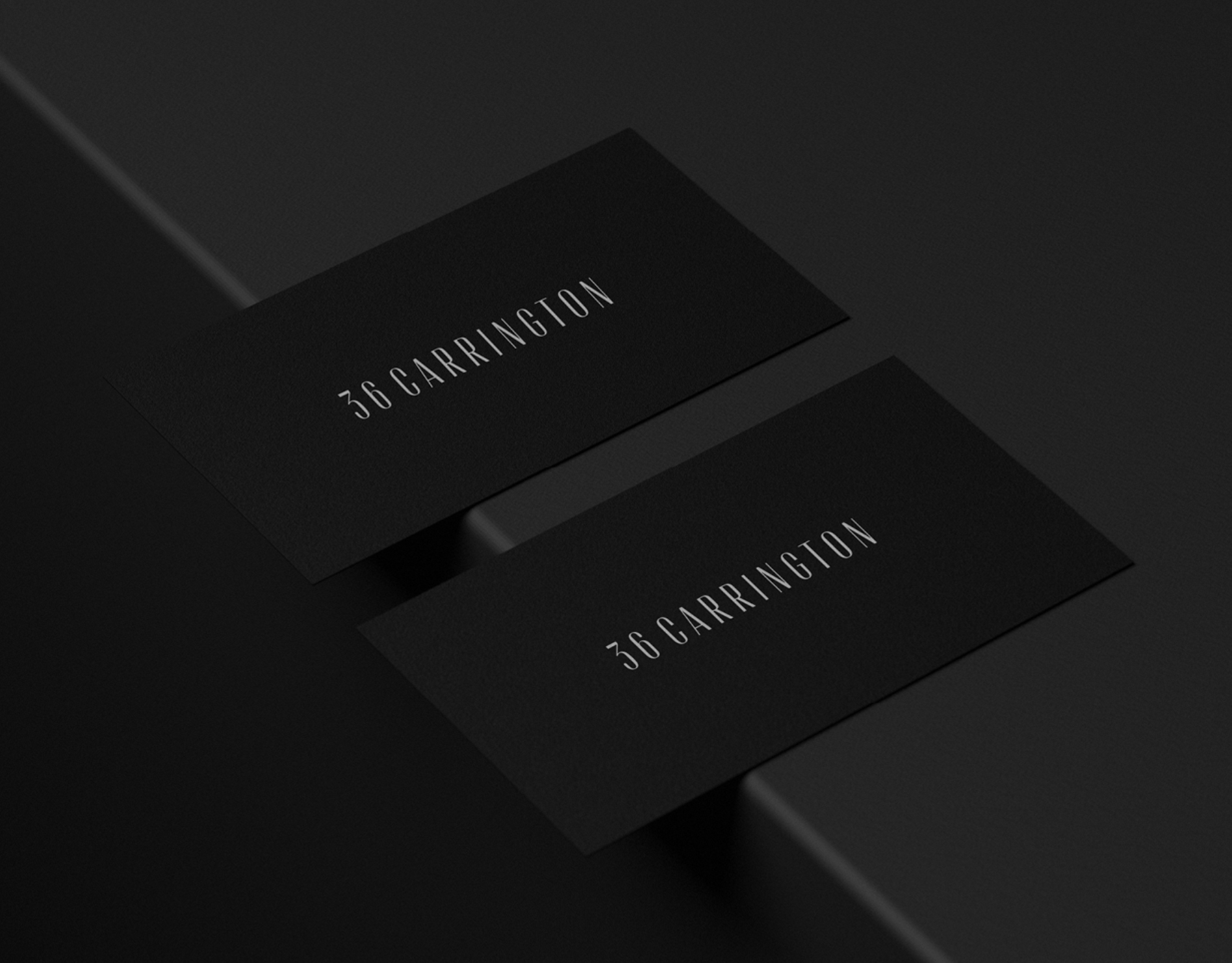 Two black business cards with white text '36 Carrington' displayed on a black background with minimalist geometric shapes.