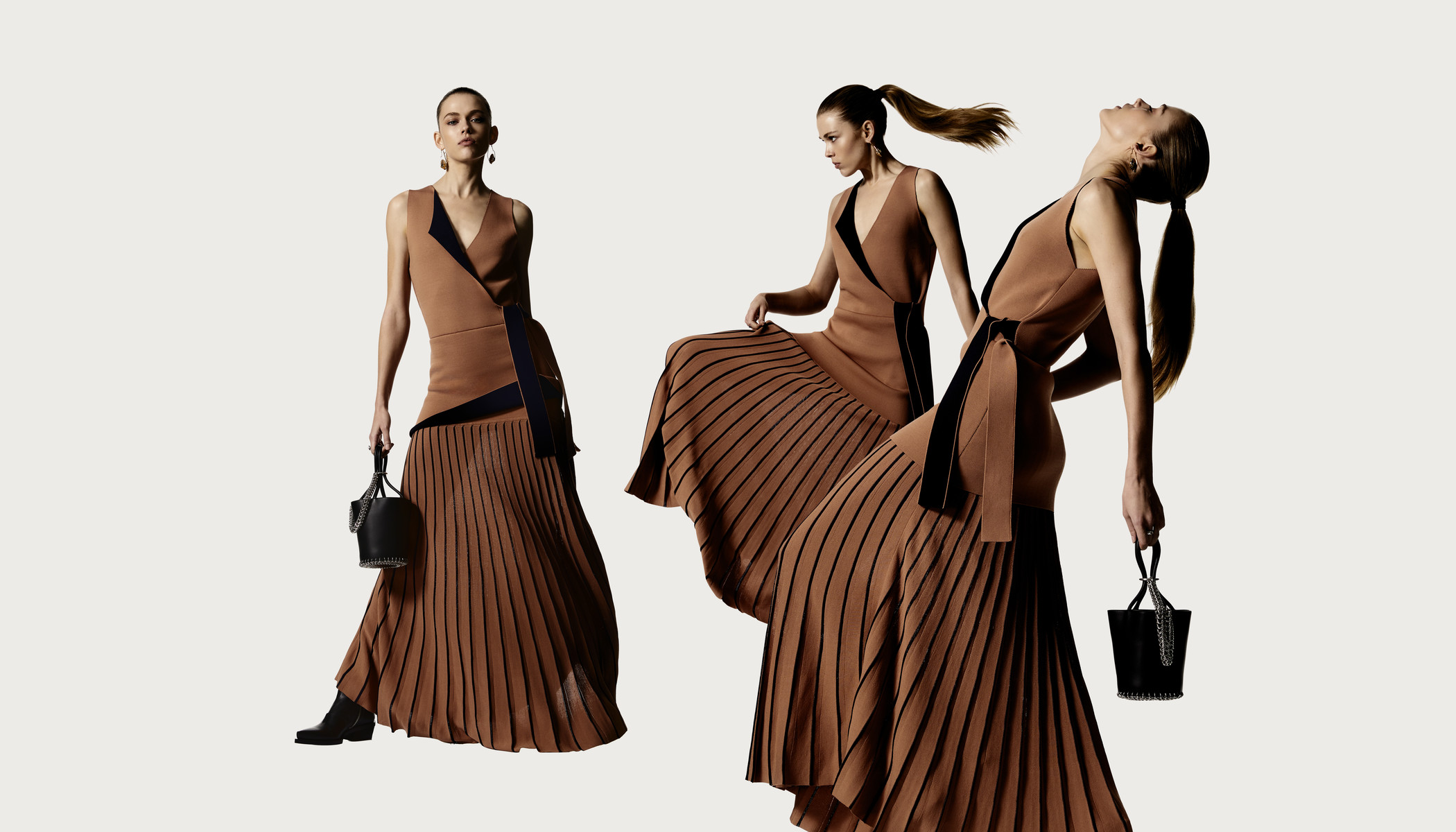 Three women pose in tan dresses with black accents and black bucket bags against a light background in a fashion editorial.