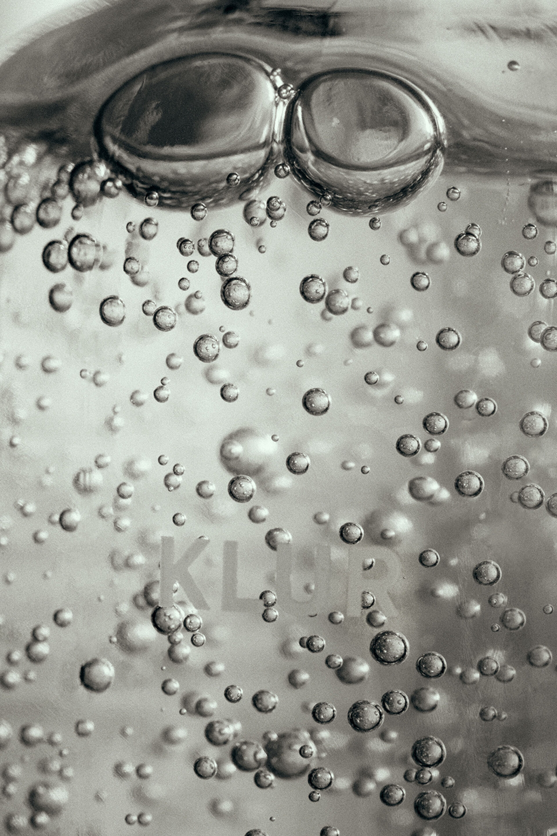 Close-up of clear water with numerous small air bubbles suspended within, creating a refreshing and effervescent visual texture.