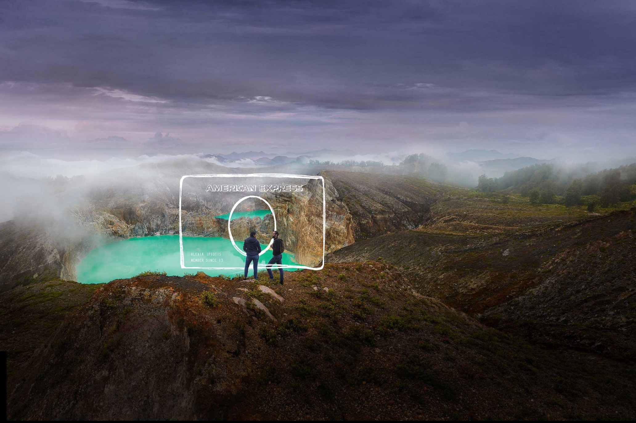Two people stand on a mountain overlooking a lake, with an augmented-reality American Express card graphic in the foreground.