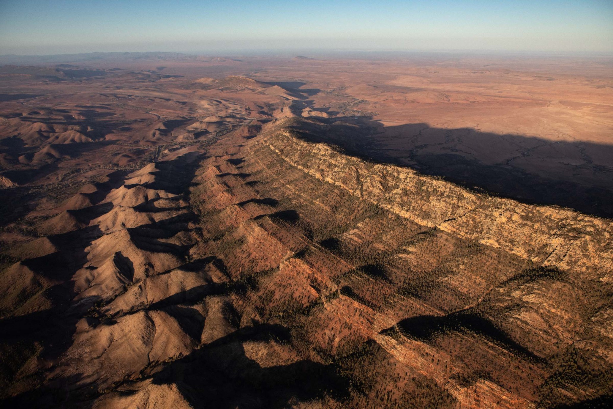Aerial view captures the rugged beauty of the Flinders Ranges in South Australia, highlighting the mountainous landscape and desert terrain.