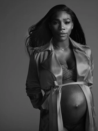 Serena Williams in a satin trench coat and delicate necklace against a seamless studio background