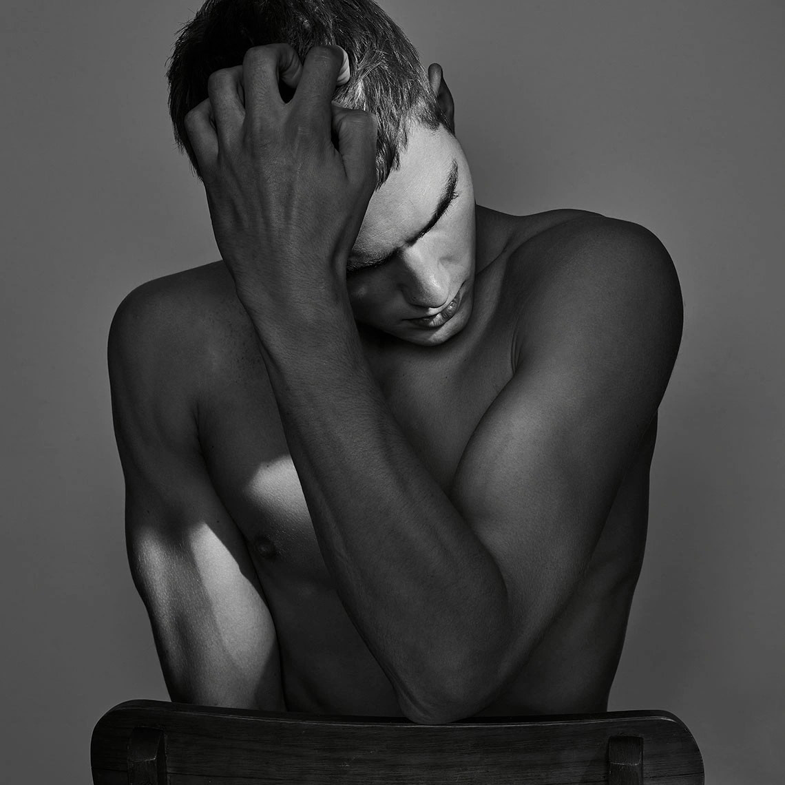 Monochrome portrait of a shirtless man running a hand through his hair with eyes closed, by photographer Jez Smith