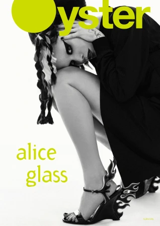 Oyster magazine cover featuring a stylishly dressed woman with braids, unique shoes, and dramatic makeup against a white backdrop.
