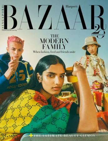 Harper's Bazaar Singapore cover featuring three fashion models in bright clothing, enjoying an outdoor picnic scene under a blue sky.