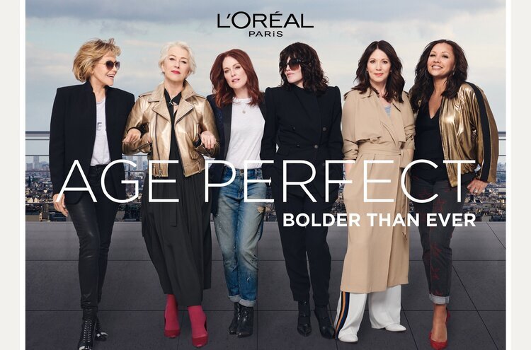 L'Oréal Paris ad features five adult women in diverse fashions posing on a rooftop, with city skyline visible, promoting 'Age Perfect'.