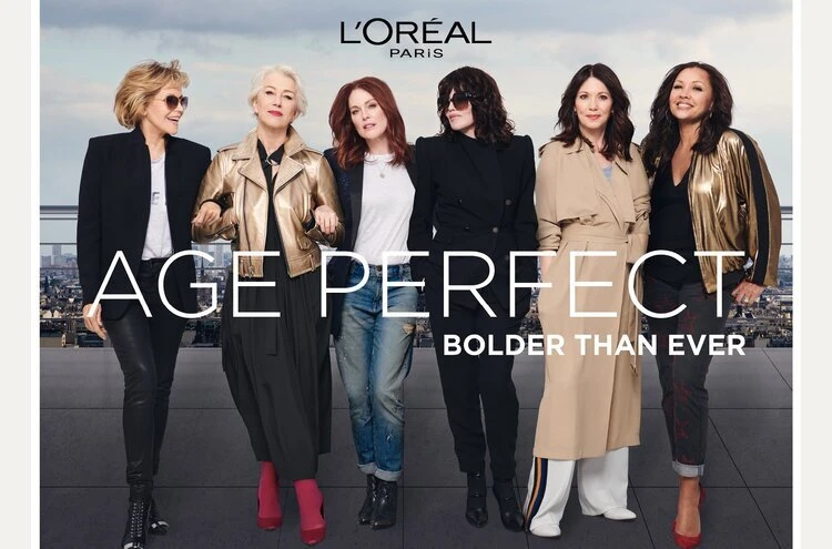 L'Oréal Paris ad features five adult women in diverse fashions posing on a rooftop, with city skyline visible, promoting 'Age Perfect'.