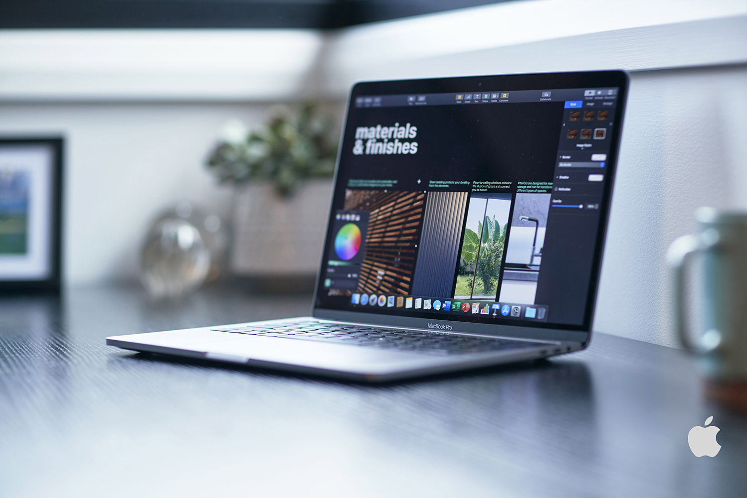 Laptop on a dark wood desk displaying materials and finishes on the screen in an indoor setting with natural light.