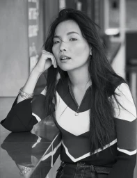 Black and white portrait of an Asian woman in a striped top resting her chin on her hand, styled by Gavin Anesbury in Sydney.