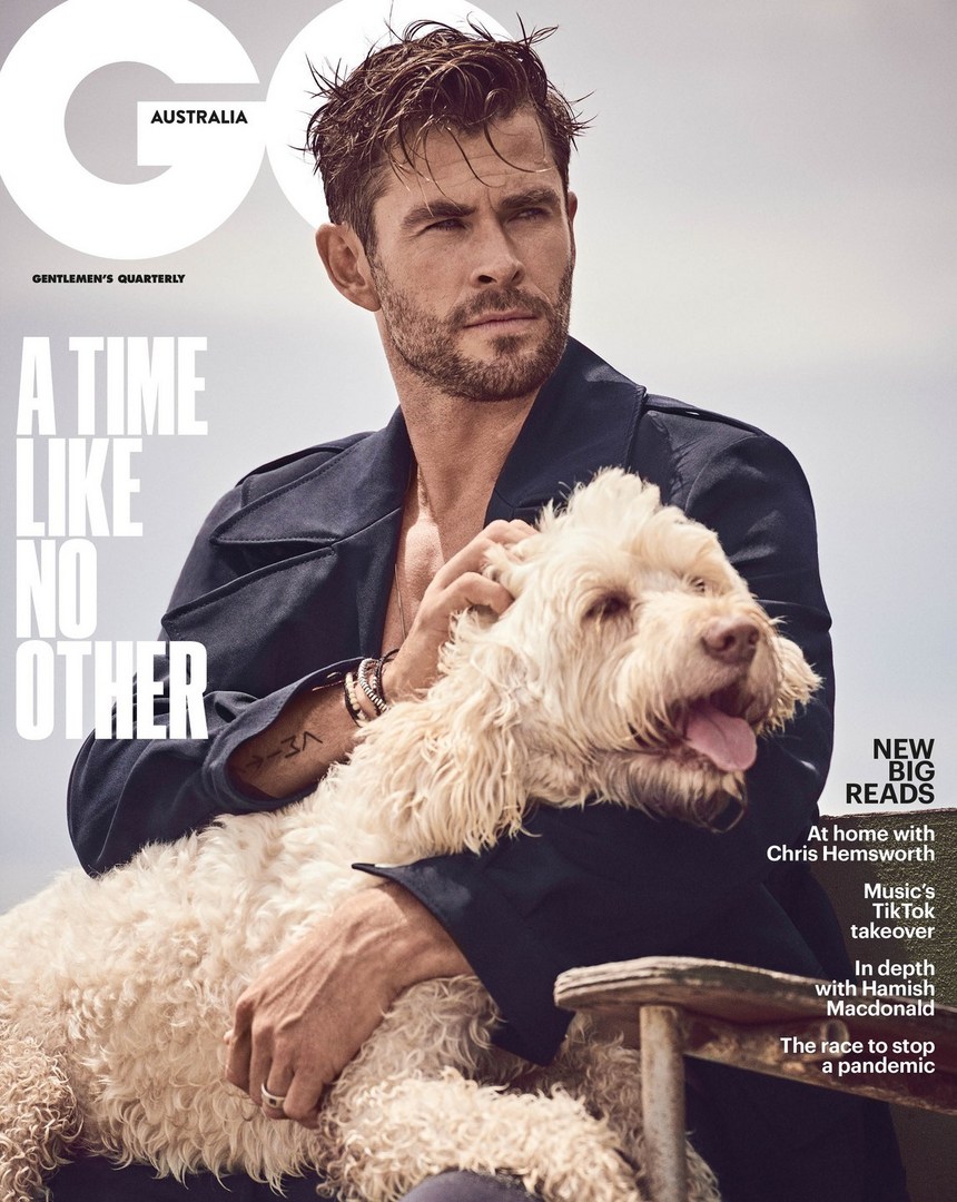 GQ magazine cover featuring Chris Hemsworth and a dog. Hemsworth in a blue jacket, sitting with the dog in his lap in an outdoor setting.