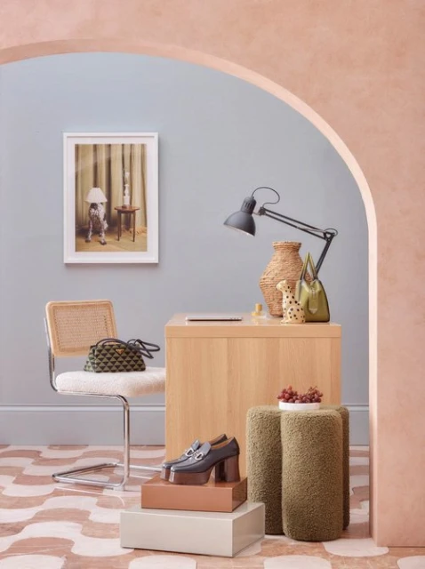 Interior room scene featuring a desk, chair, table lamp, shoes, and decorative items, all showcased in a styled, visually appealing arrangement.