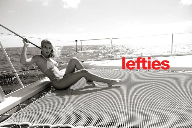 A woman in a bikini poses on a yacht, enjoying the sun and sea in a monochrome image with red text overlay, creating a fashion-forward aesthetic.