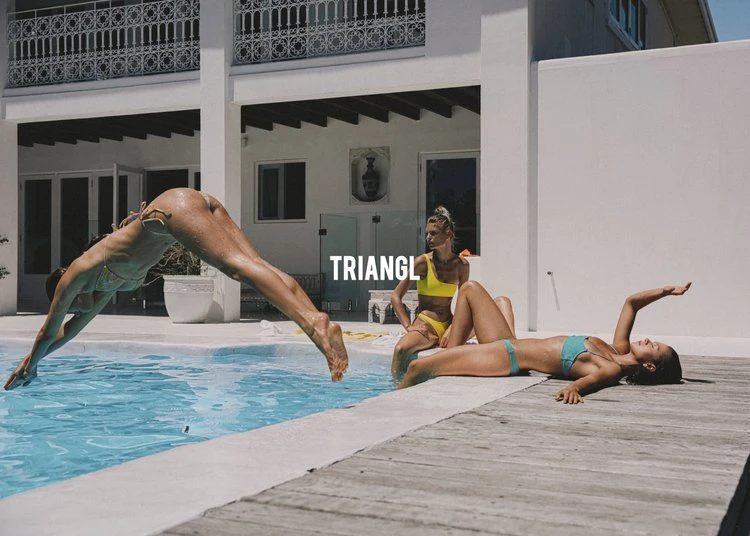Three adult females in swimsuits near a pool; one is diving in the pool, the others are sunbathing by a modern white villa.