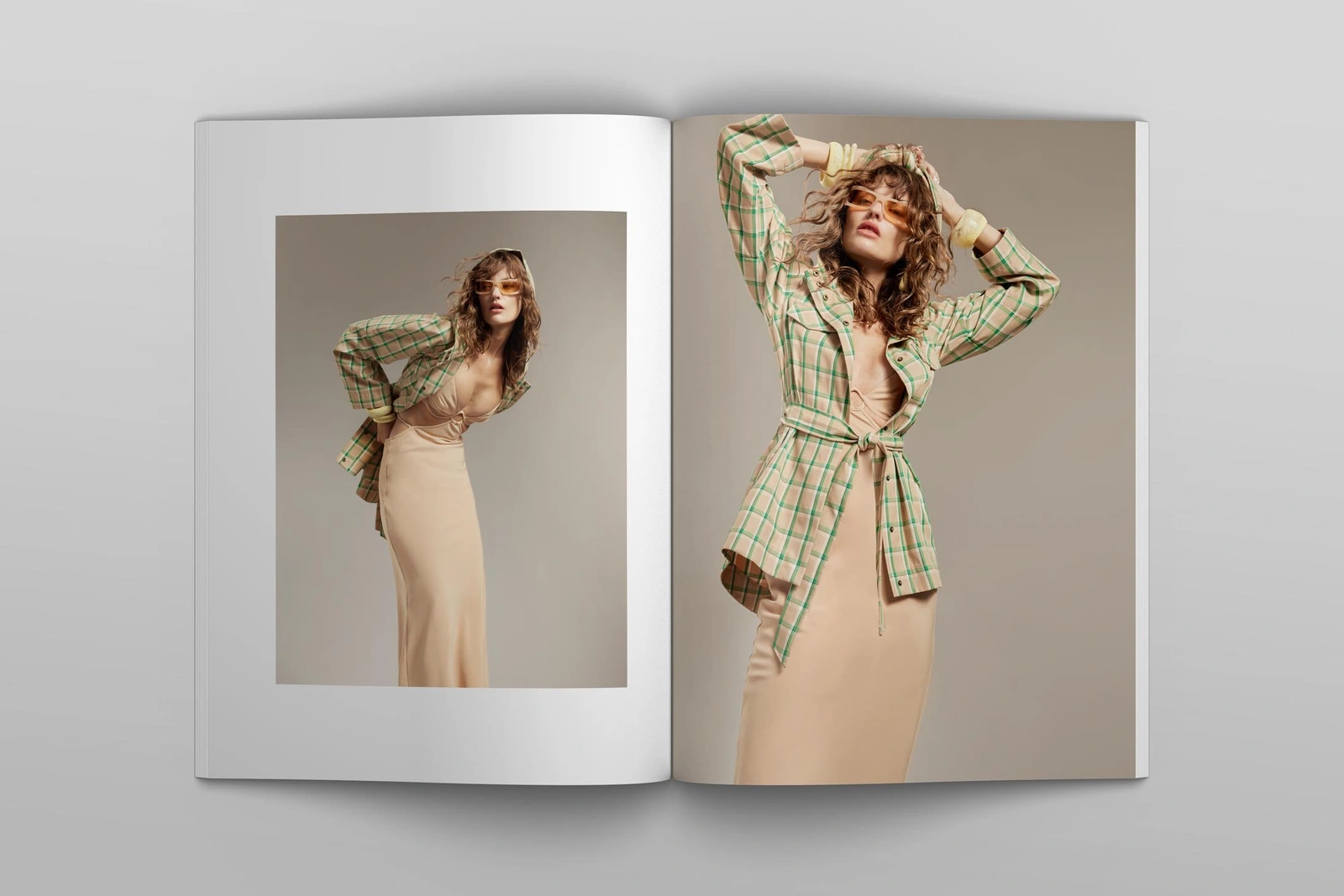 Model wearing a plaid jacket and beige dress displayed on an open magazine spread against a plain background