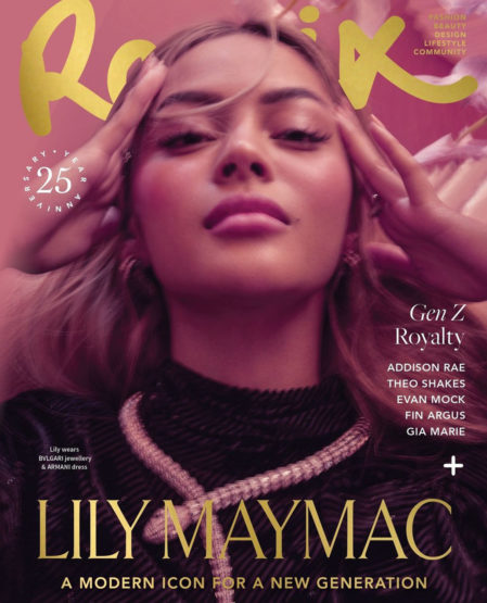 Close-up magazine cover portrait of a young woman with long hair wearing a black textured top and silver necklace against a pink backdrop.