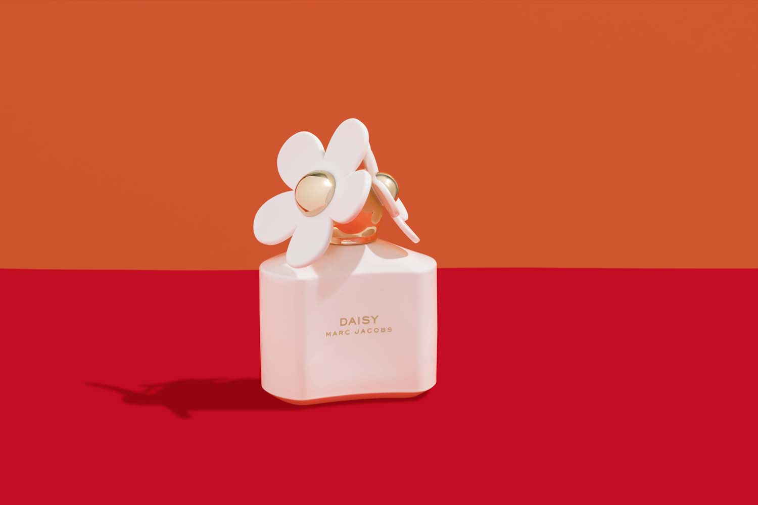 Daisy Marc Jacobs perfume bottle on a vibrant background with orange and red hues creating a striking contrast.