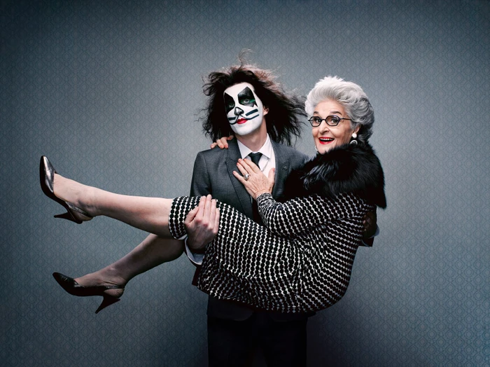Man in face paint carrying an elderly woman in a patterned dress photographed by Toby Burrows in Sydney