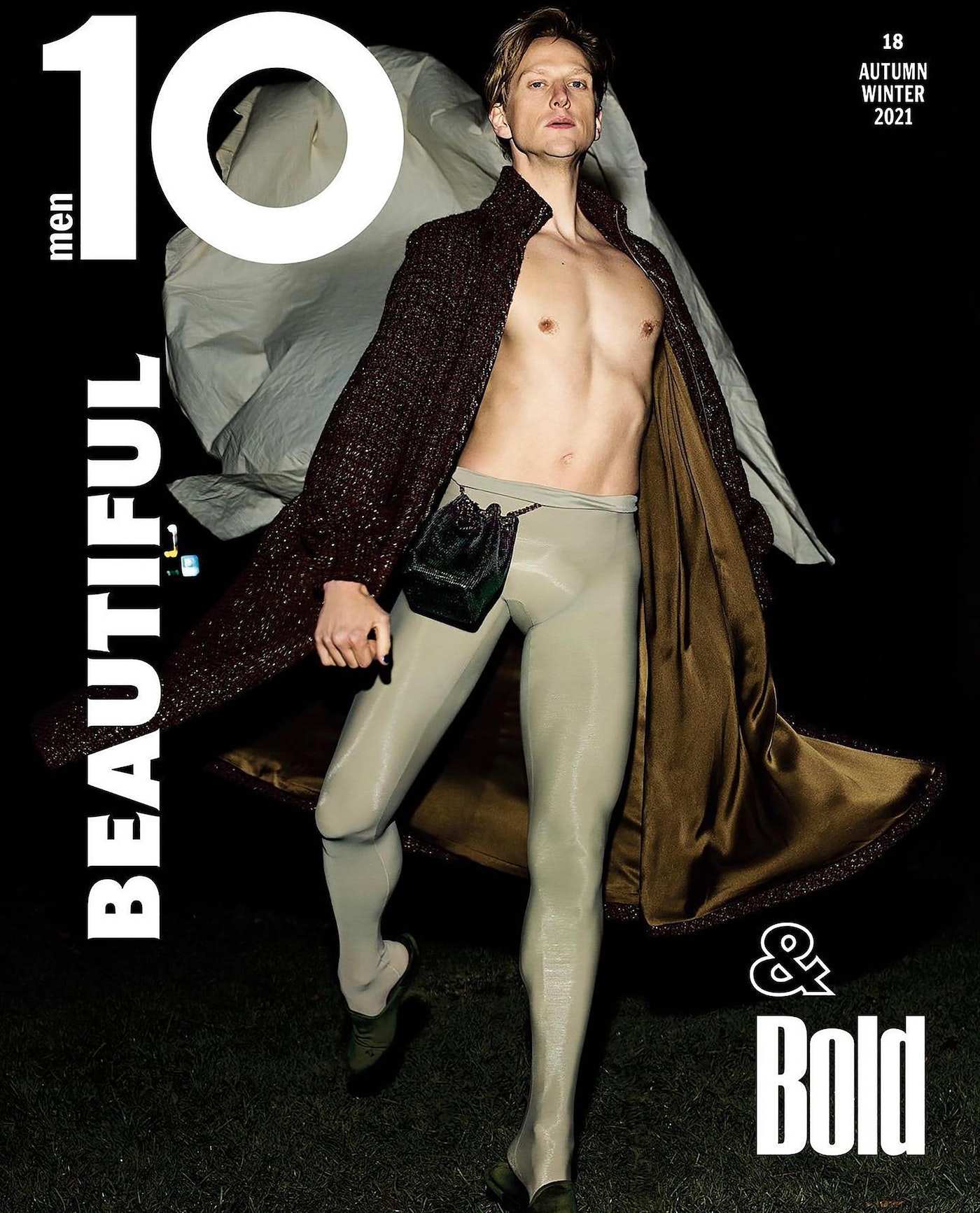 Magazine cover featuring a man in a long robe and tights, showcasing fashion and editorial style against a dark background.