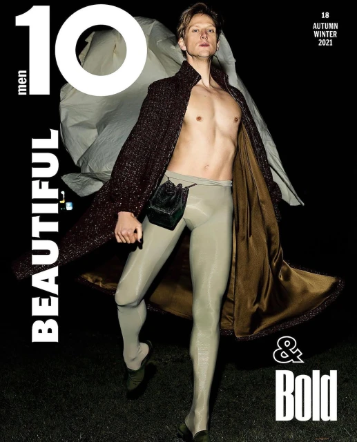 Magazine cover featuring a man in a long robe and tights, showcasing fashion and editorial style against a dark background.