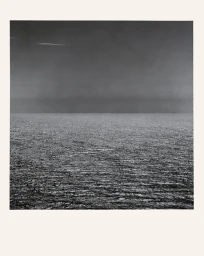 Black and white photograph of an expansive ocean under a dark horizon line by Kelly Geddes