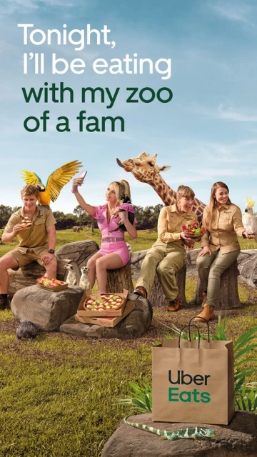Whimsical ad with four people and various animals around food and an Uber Eats bag in a grassy field on a sunny day.