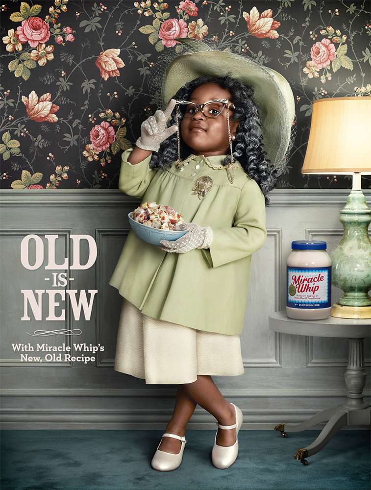 Young girl dressed as an elderly woman poses in front of floral wallpaper, holding a bowl of salad next to Miracle Whip.