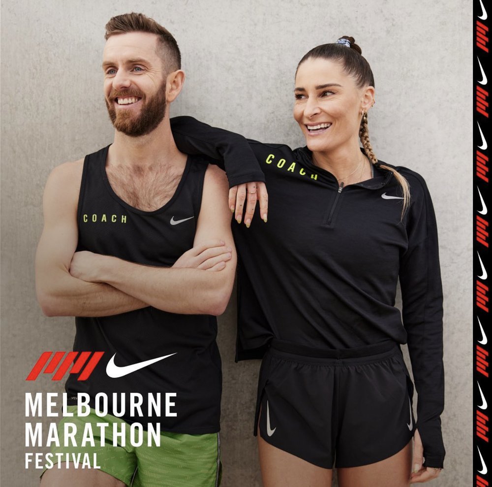 Two smiling athletes, a man and a woman, pose against a concrete wall wearing Nike apparel to promote the Melbourne Marathon Festival.