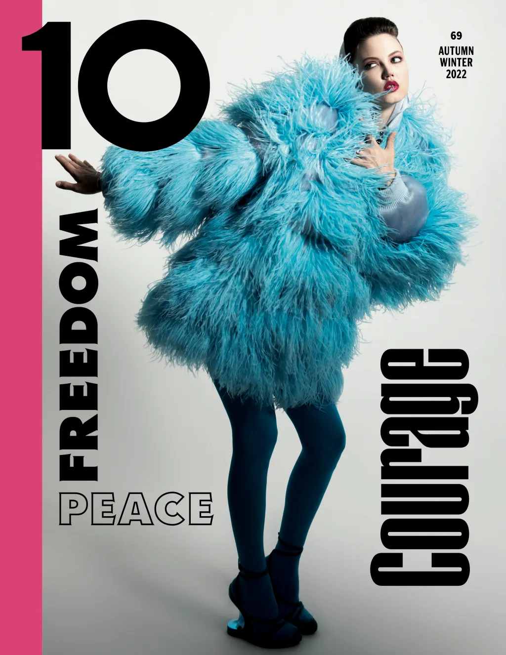 Magazine cover featuring a woman in a blue, feathered coat, blue tights, and platform shoes, with large text reading 'FREEDOM,' 'PEACE,' 'COURAGE.'