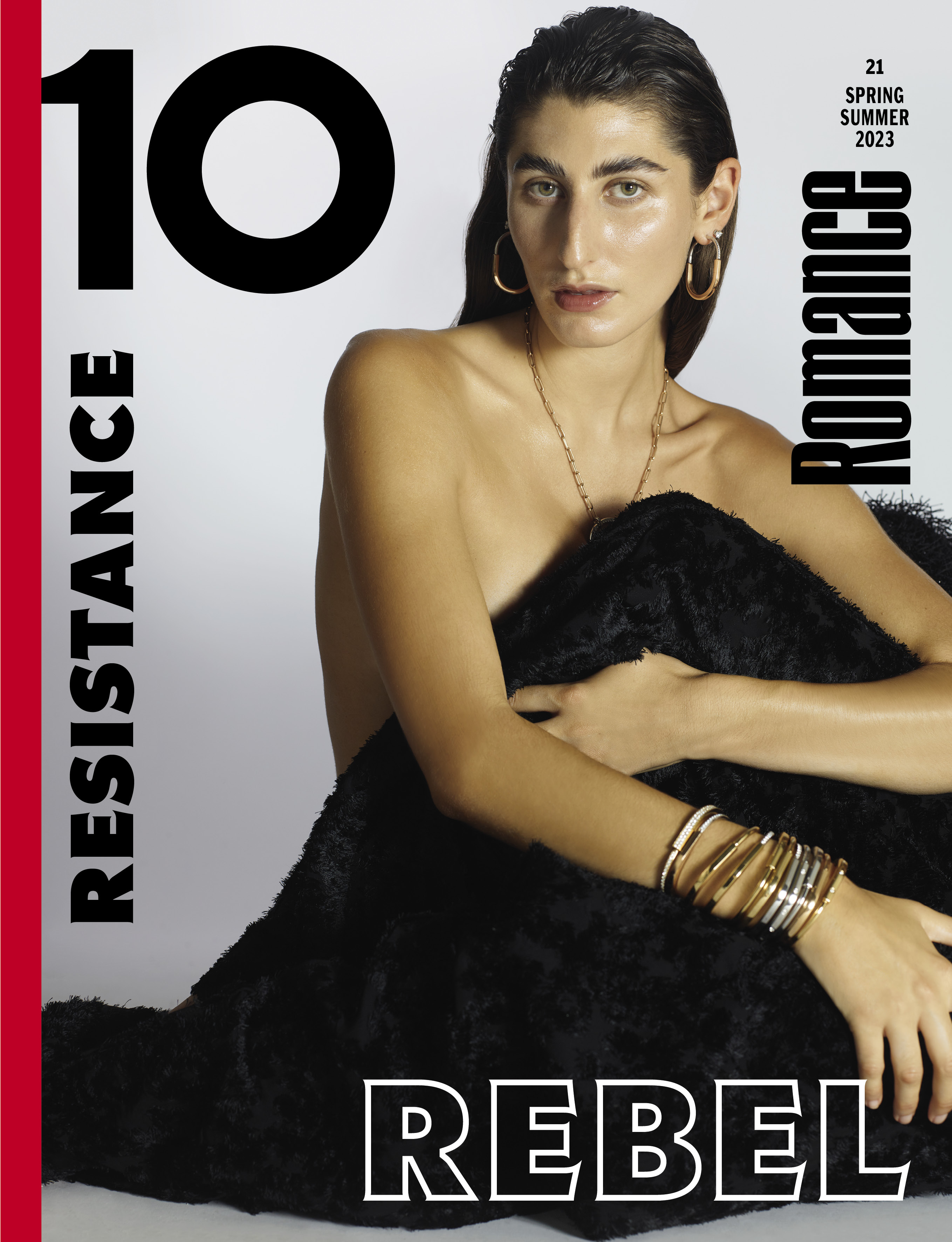 Fashion magazine cover featuring a woman with wet hair and gold jewellery, with a black fluffy blanket and white and black text.