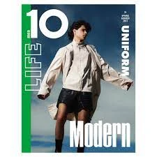 Magazine cover featuring a young adult posing in an open beige jacket and black skirt against a blurred outdoor backdrop.