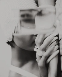 Close-up monochrome portrait of a person wearing a white knit cap and chunky rings, styled by Joseph Gardner
