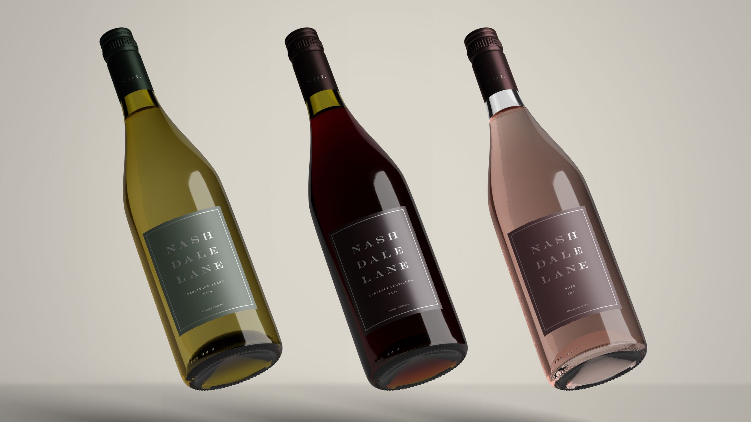 Three floating wine bottles, one white, one red, and one rosé, against a light beige studio background.