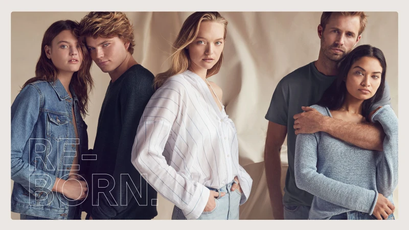 Group of five models in casual apparel posing against a draped neutral studio backdrop with overlaid text